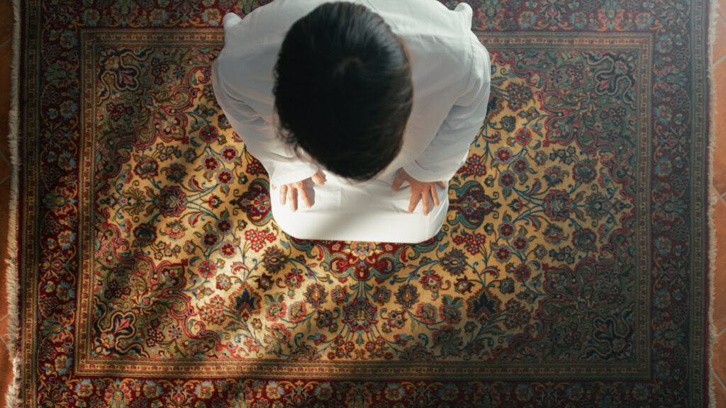 man kneeling on carpet prays during ramadan