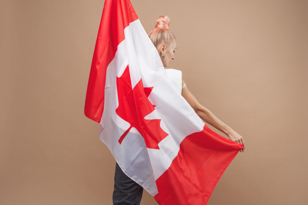 beautiful blonde woman standing with canadian flag