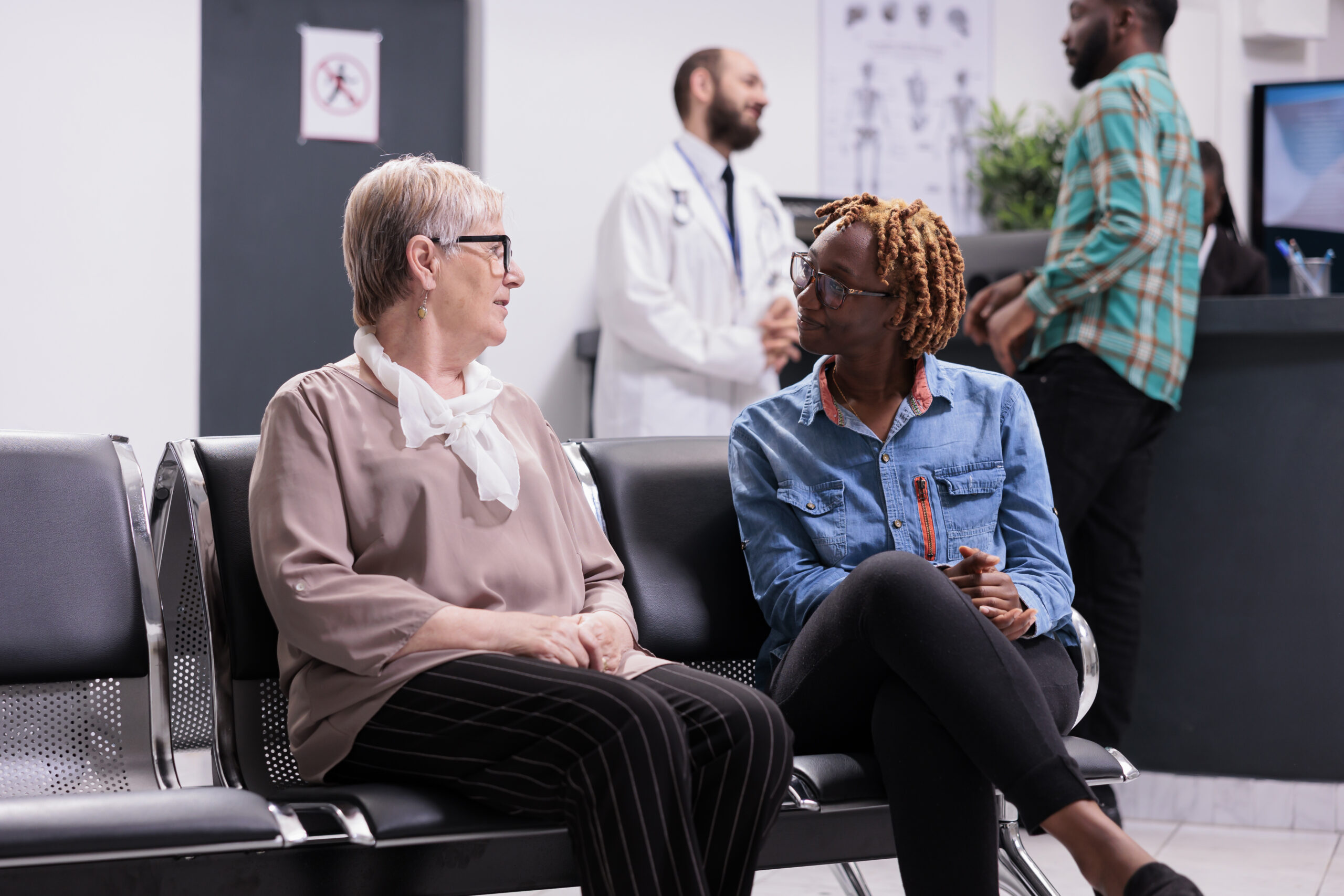diverse people sitting in hospital reception waiting room