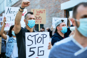 crowd of people with protective face mask protesting against 5g network.