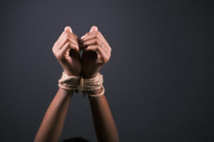 hand tied with rope against black background