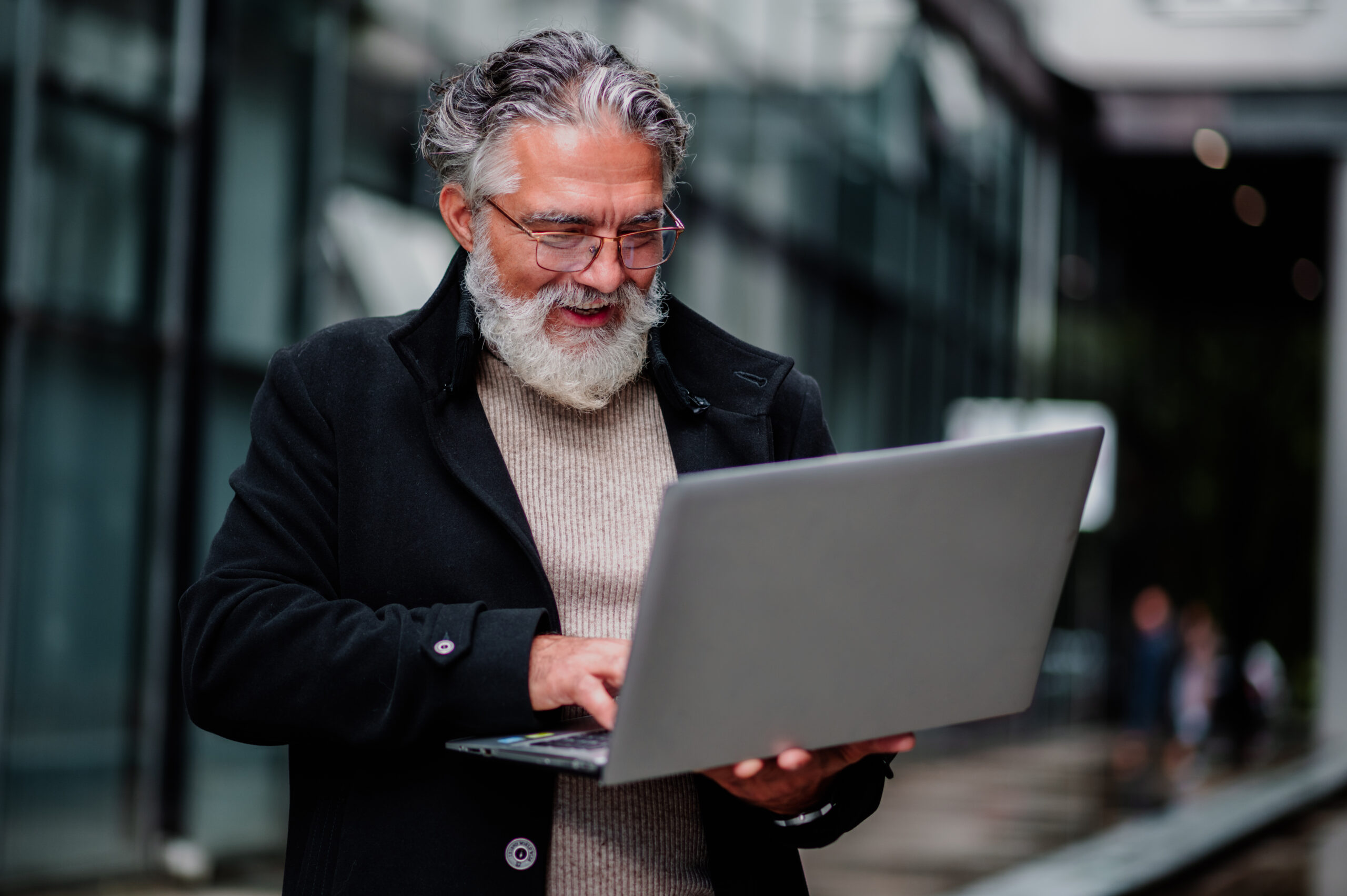 portrait of a senior businessman using laptop and sitting on a b