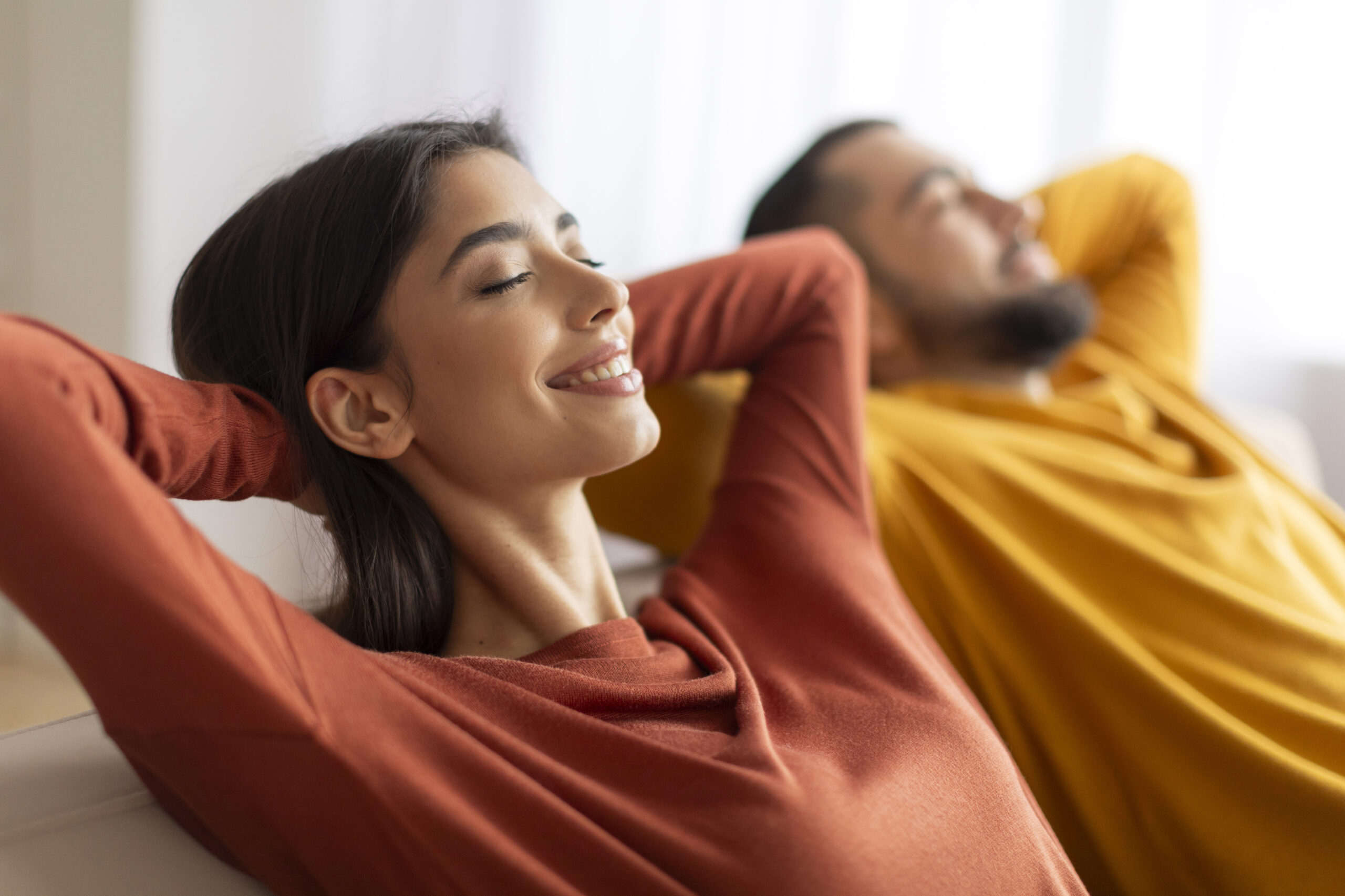 relaxation concept. happy relaxed young couple leaning back on sofa at home