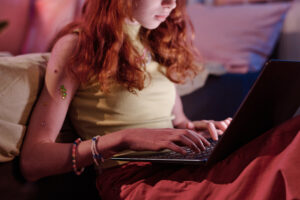 teen girl typing on laptop in evening