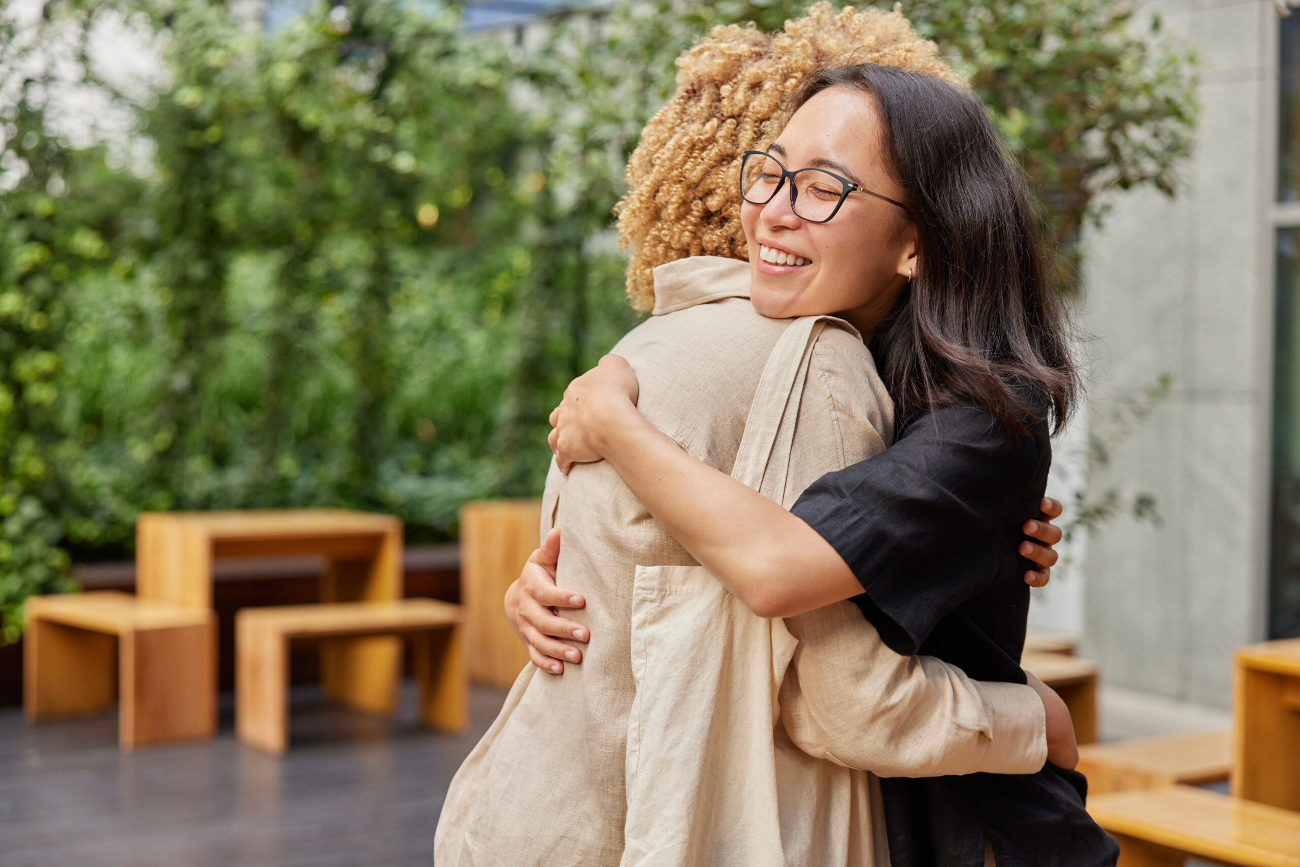 two best friends havent seen each other for long time meet together at street embrace warmly with love happy to meet accidentaly at street have good friendly relationships. greeting concept.