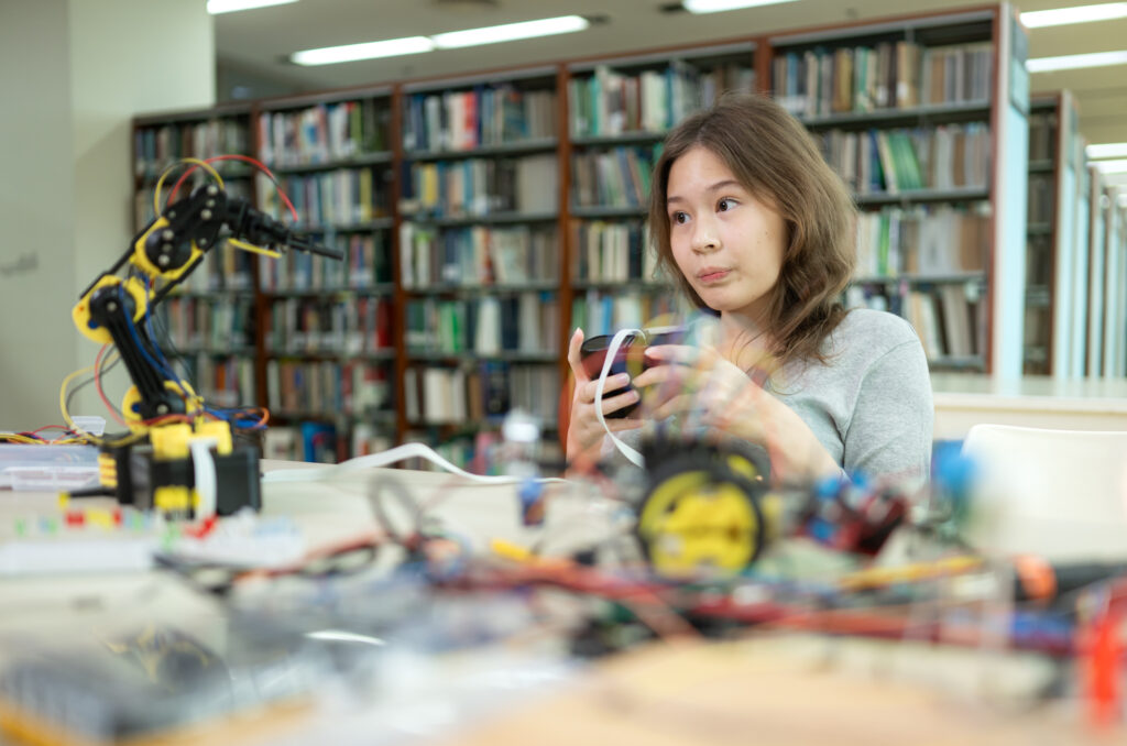 a teenage girl student in a robotics project during a stem class