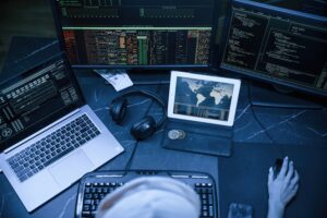 top view. young professional female hacker is indoors by computer with lot of information on displays