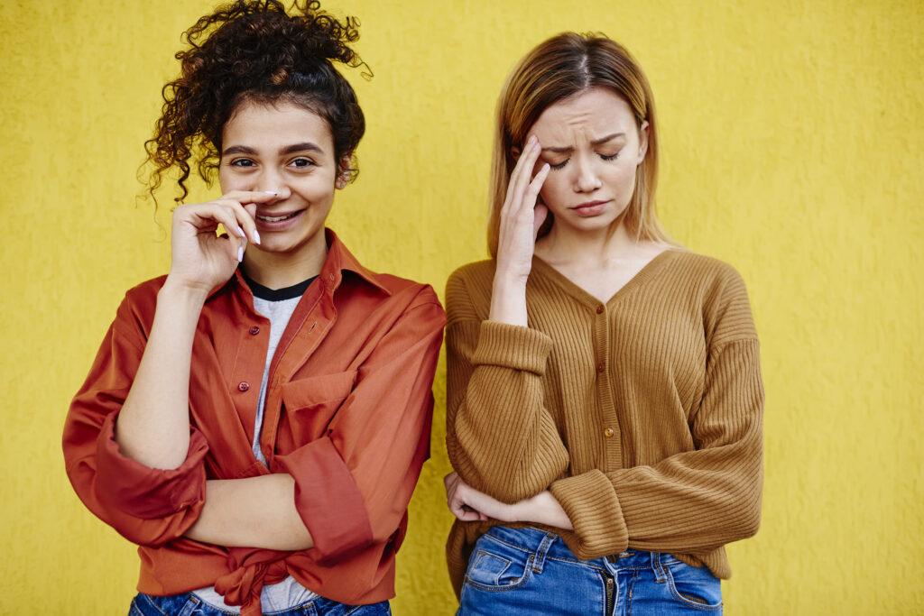 cheerful woman with upset female friend