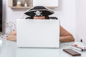 pirate themed hacker engaging in online scams at a modern home o