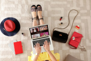 woman and laptop with fashion blogger site on floor, top view