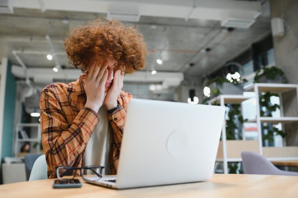caucasian hipster guy enjoying distance job in coffee shop, male freelancer in trendy glasses sitting in cafeteria with modern laptop device