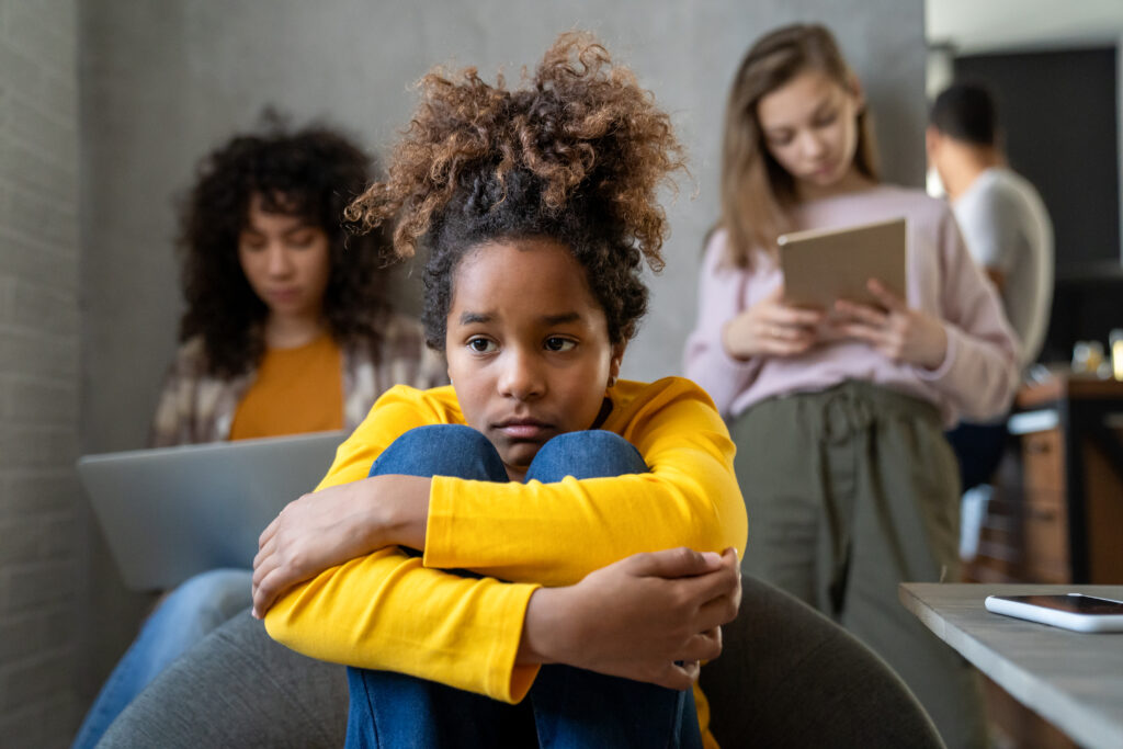 frustrated little black child suffer at home because family have addiction to digital gadgets.